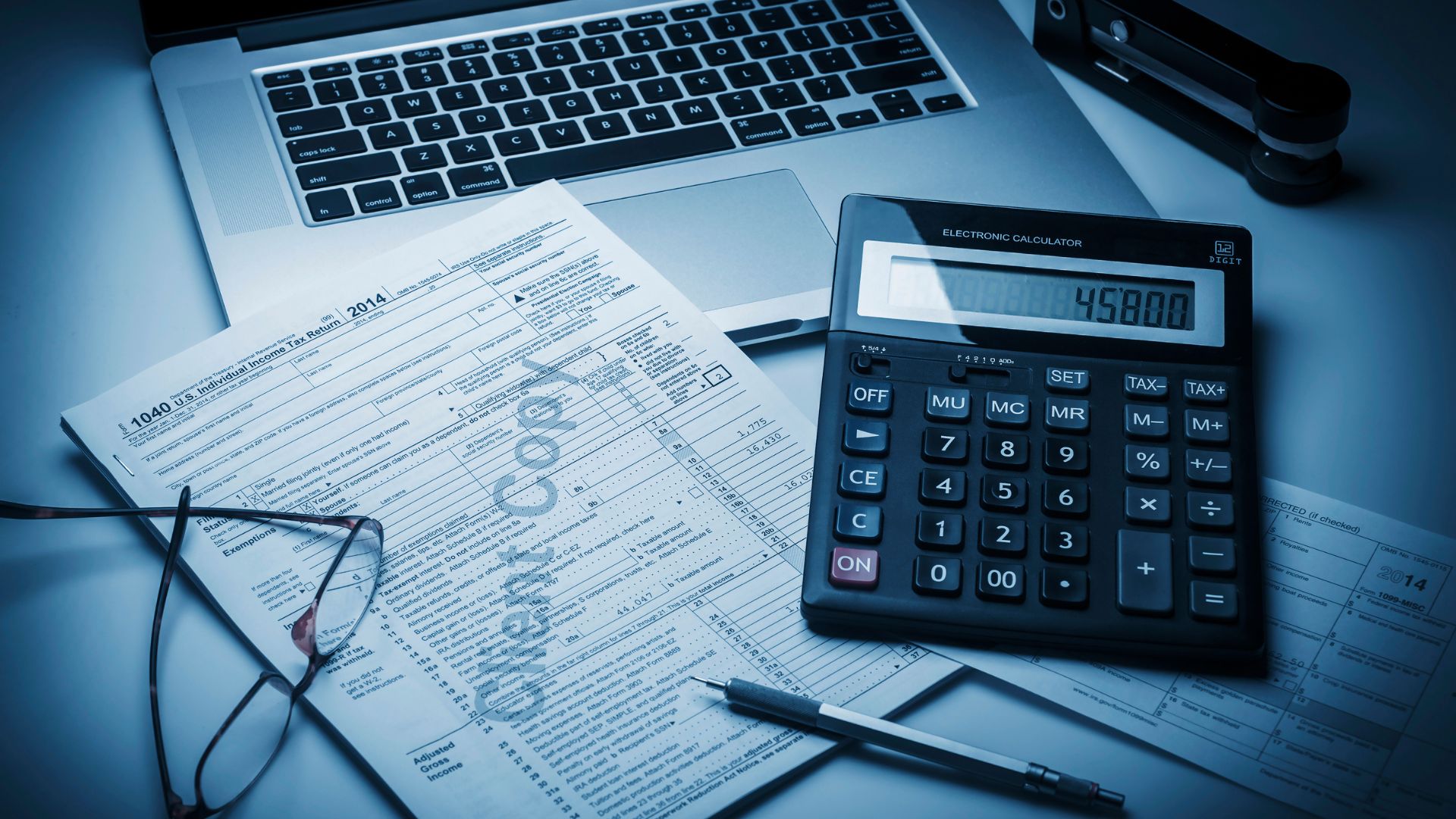 Rozliczenia i księgowość dla firm — praca z kalkulatorem i laptopem
